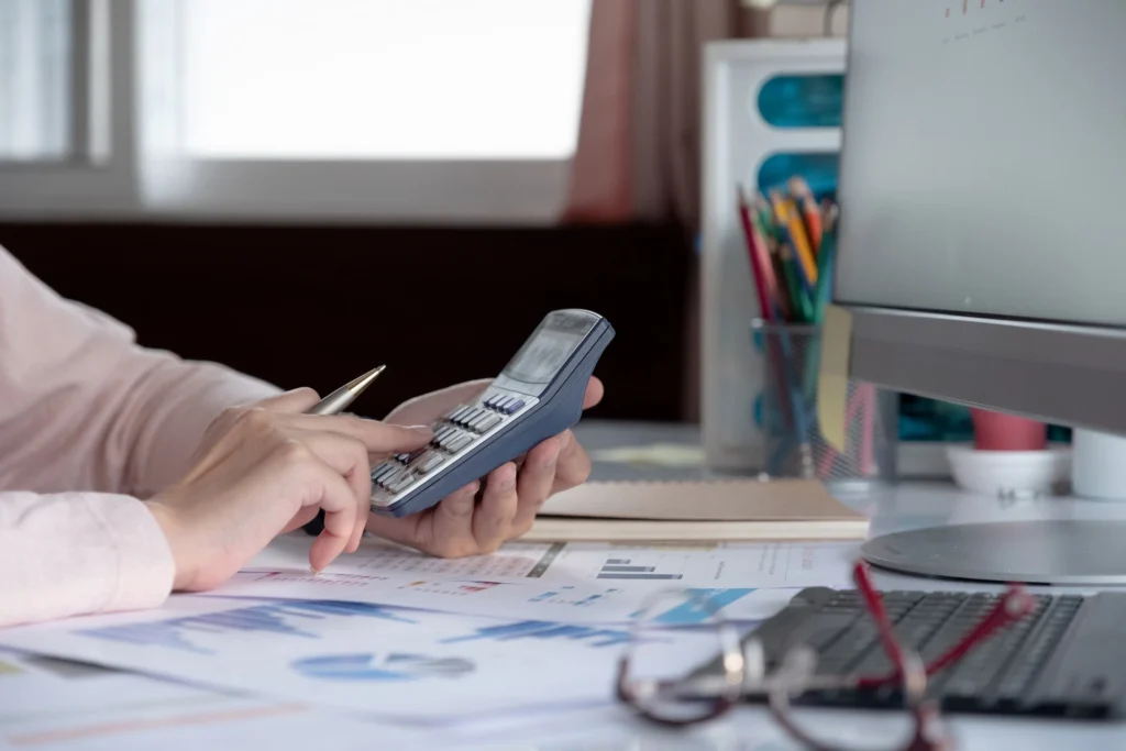 close-up-business-woman-using-calculator-and-lapto-2023-11-27-05-20-45-utc-_1_